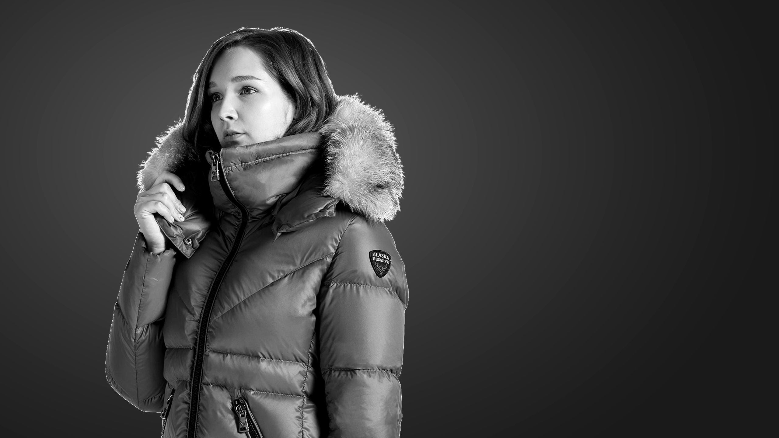 Woman in a Zyra down jacket with fox fur hood, black and white